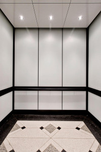 FSRT761 Интерьер лифта Levele-105 с основными панелями из вивихромного хромового стекла с белой прослойкой и отделкой opalex; панели перил из плавленого графита с отделкой из песчаника; круглые поручни из бронзы, натертой маслом, в здании Brandywine, Уилм